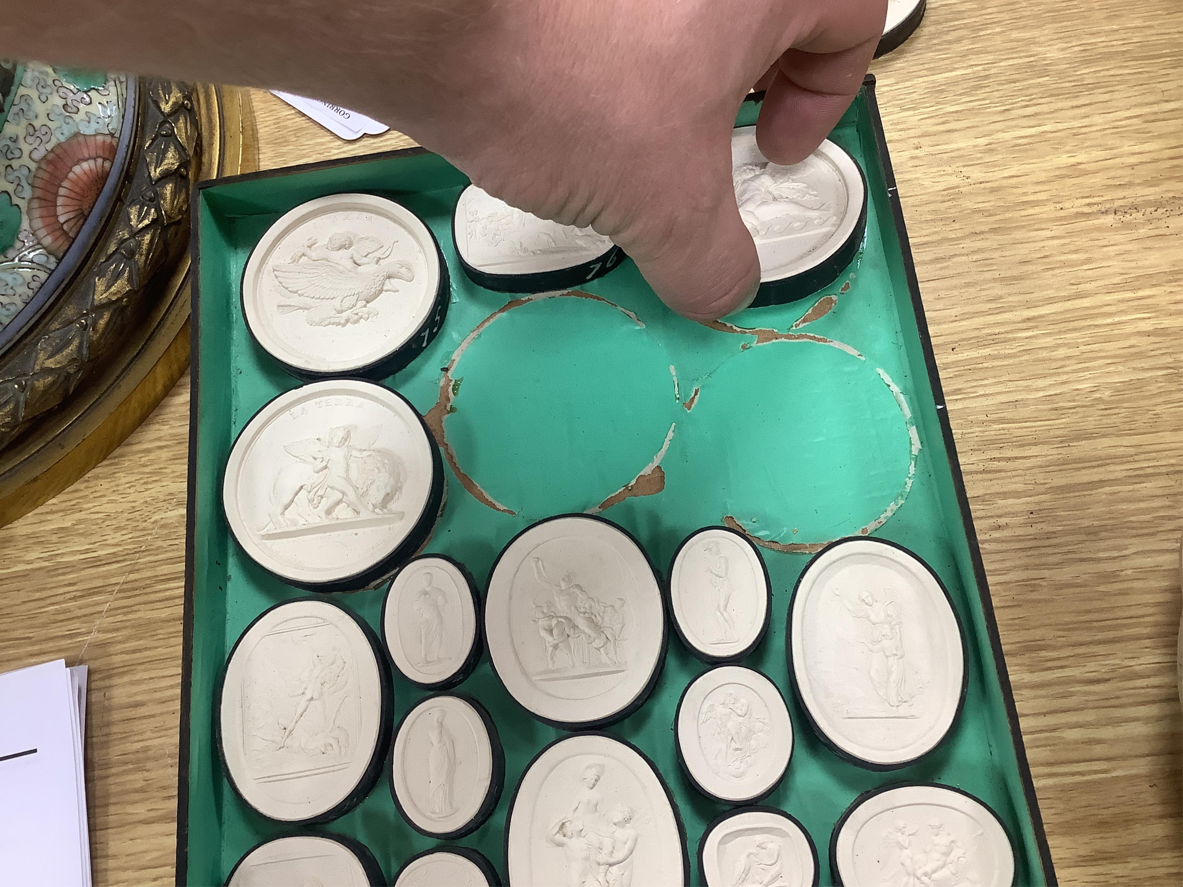 A cased set of thirty two Italian Grand Tour plaster roundels after intaglios of various subjects